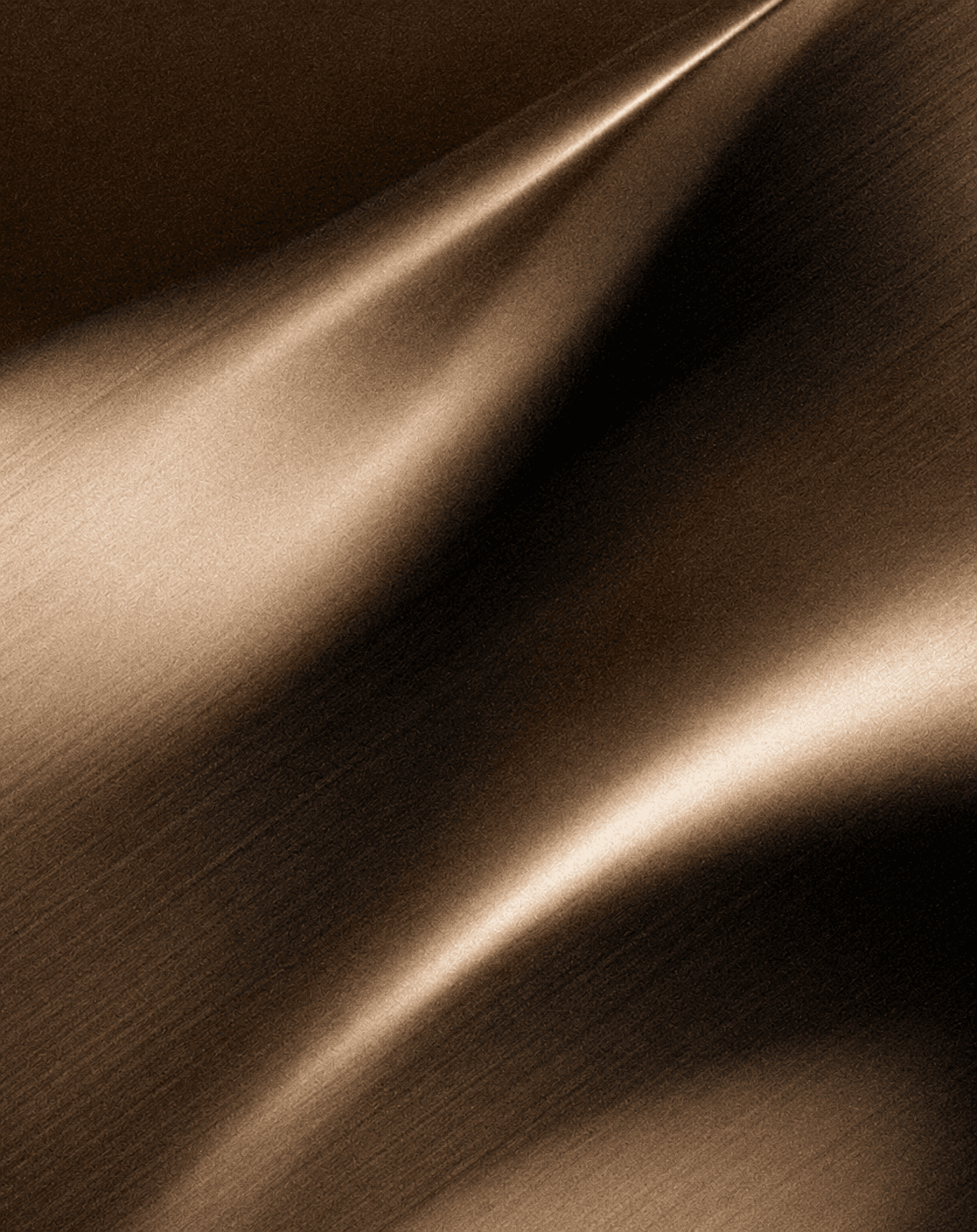 Brushed metallic surface catching warm light